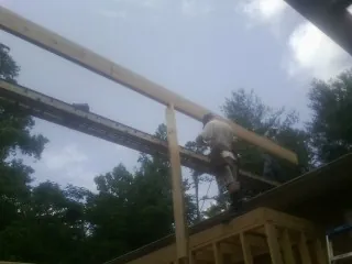 Carpenter setting a ridge beam over a new addition frame — Ice Dam Removal by Roofing Brothers in Morrison